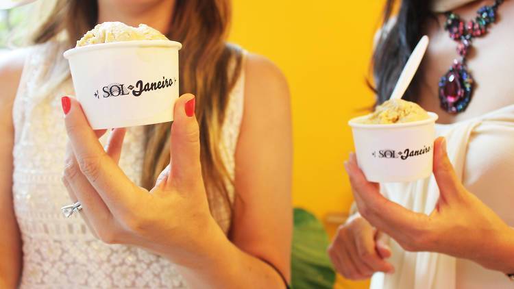 women holding ice cream in a cup that says Sol de Janeiro