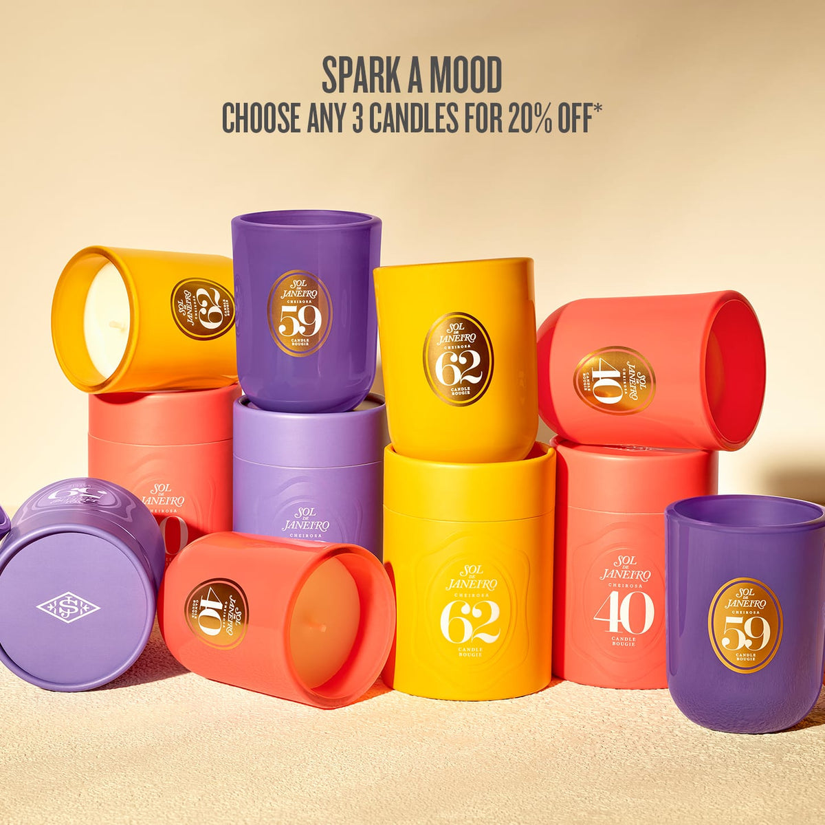 A group of colorful cylindrical candles in matching yellow, purple, and coral-red containers, arranged on a warm beige surface with promotional text at the top reading 'SPARK A MOOD CHOOSE ANY 3 CANDLES FOR 20% OFF'.