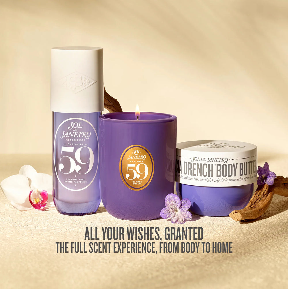 Three Sol Janeyro 59 Aged scented products arranged on a beige textured surface: a translucent lavender bottle, a purple candle with a gold circular label, and a purple body butter jar with a white lid. Decorative orchid flowers and dried wood are placed around them, with the text 'ALL YOUR WISHES, GRANTED THE FULL SCENT EXPERIENCE, FROM BODY TO HOME' at the bottom.