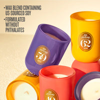 Several Sol Janvetro scented candles in colorful glass vessels are arranged on a light beige surface. Visible labels include 59, 40, 62, and 30.