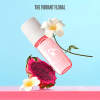 Pink perfume bottle with dragon fruit and flowers on a light blue background