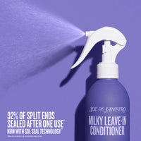 Purple spray bottle of Sol de Janeiro Milky Leave-In Conditioner with a white nozzle on a purple background.