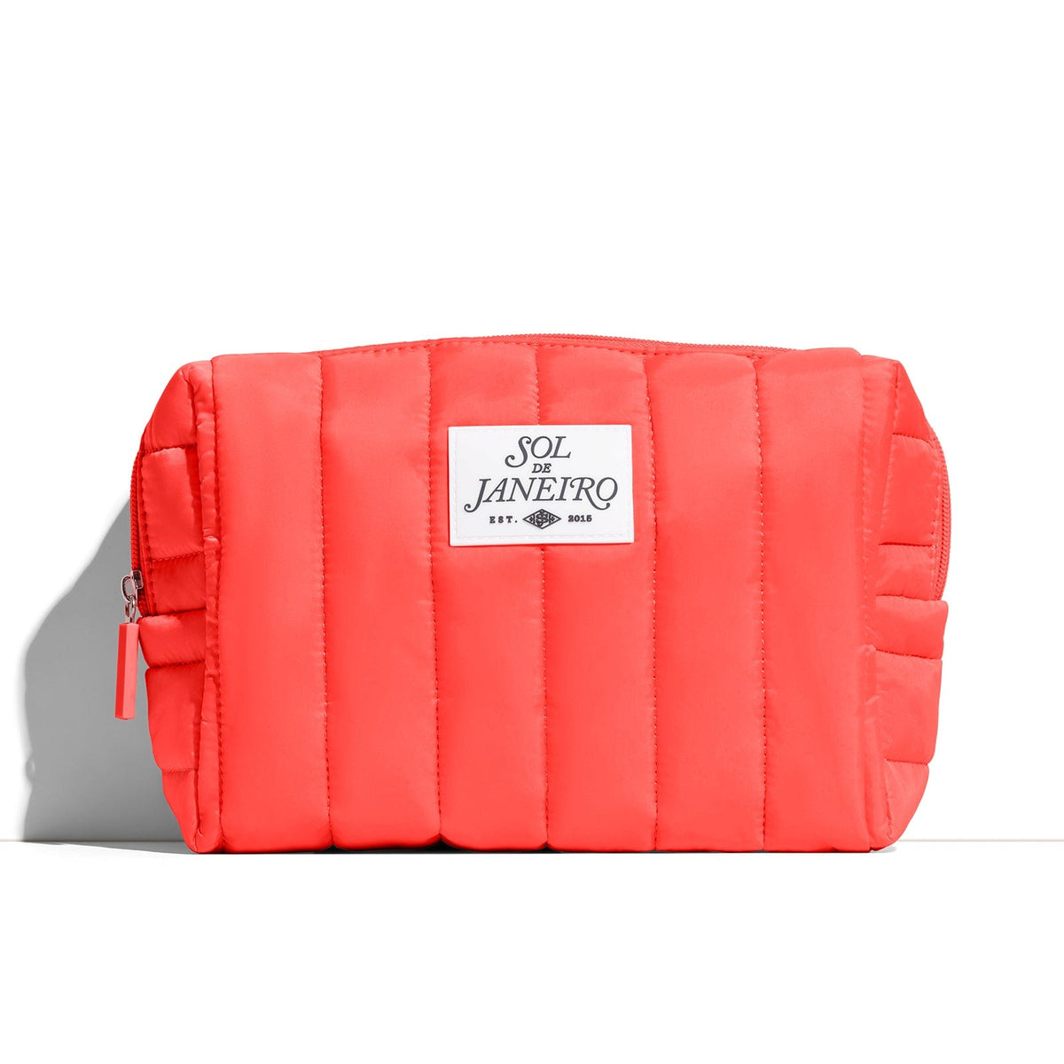 Red quilted pouch with 'Sol de Janeiro' label on a white background