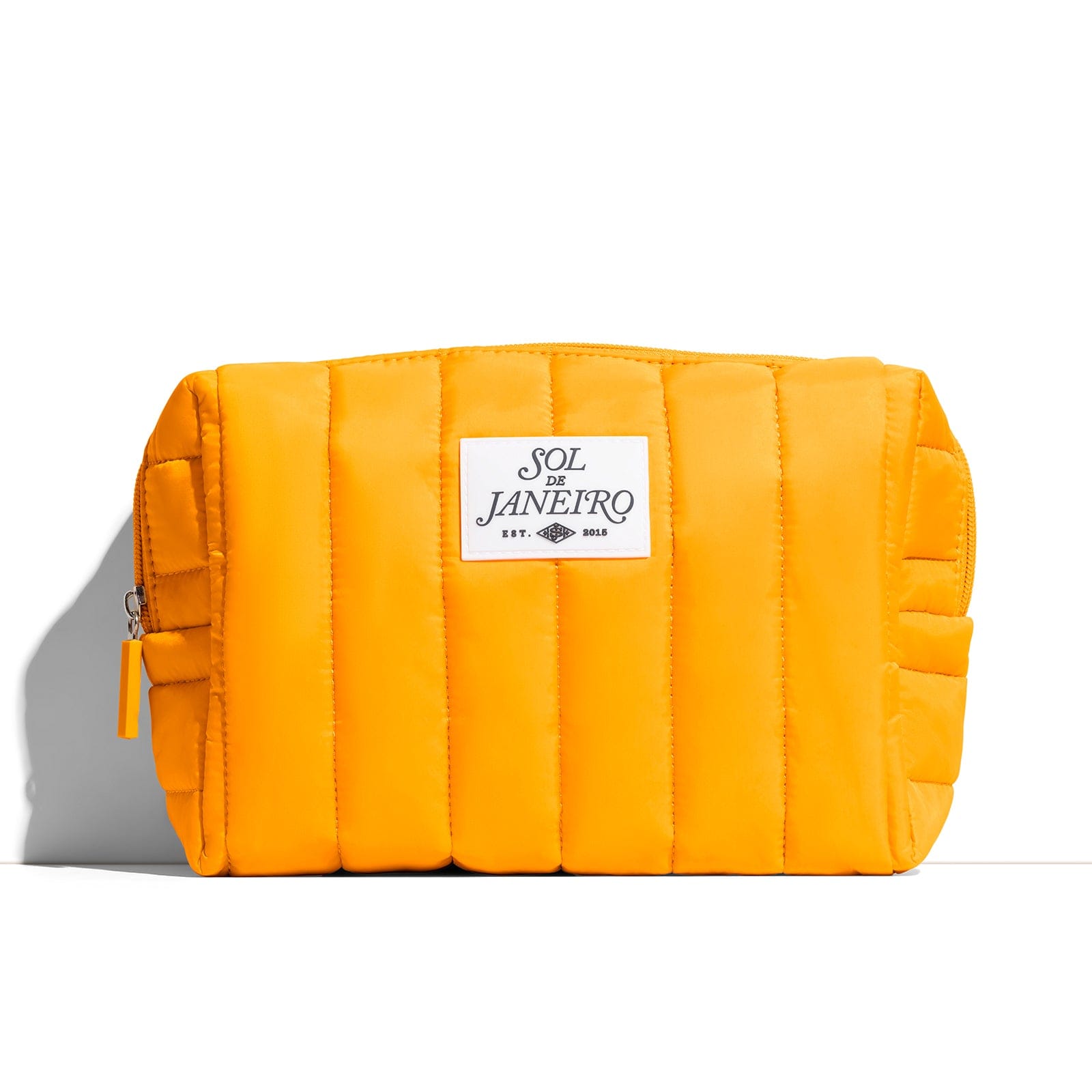Yellow quilted pouch with a brand label on a white background