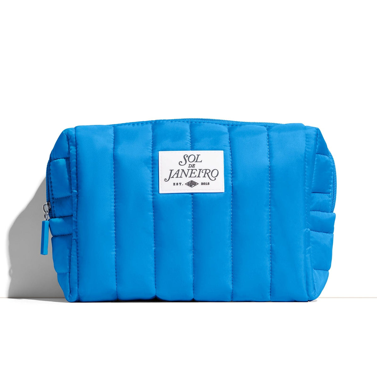 Blue quilted pouch with a visible brand label on a white background