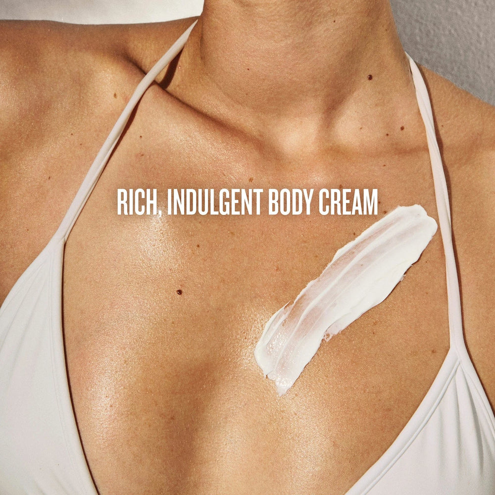 Body cream applied to shoulder with text 'Rich, Indulgent Body Cream' on a neutral background