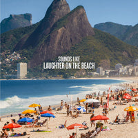 Beach scene with people, umbrellas, and mountains in the background