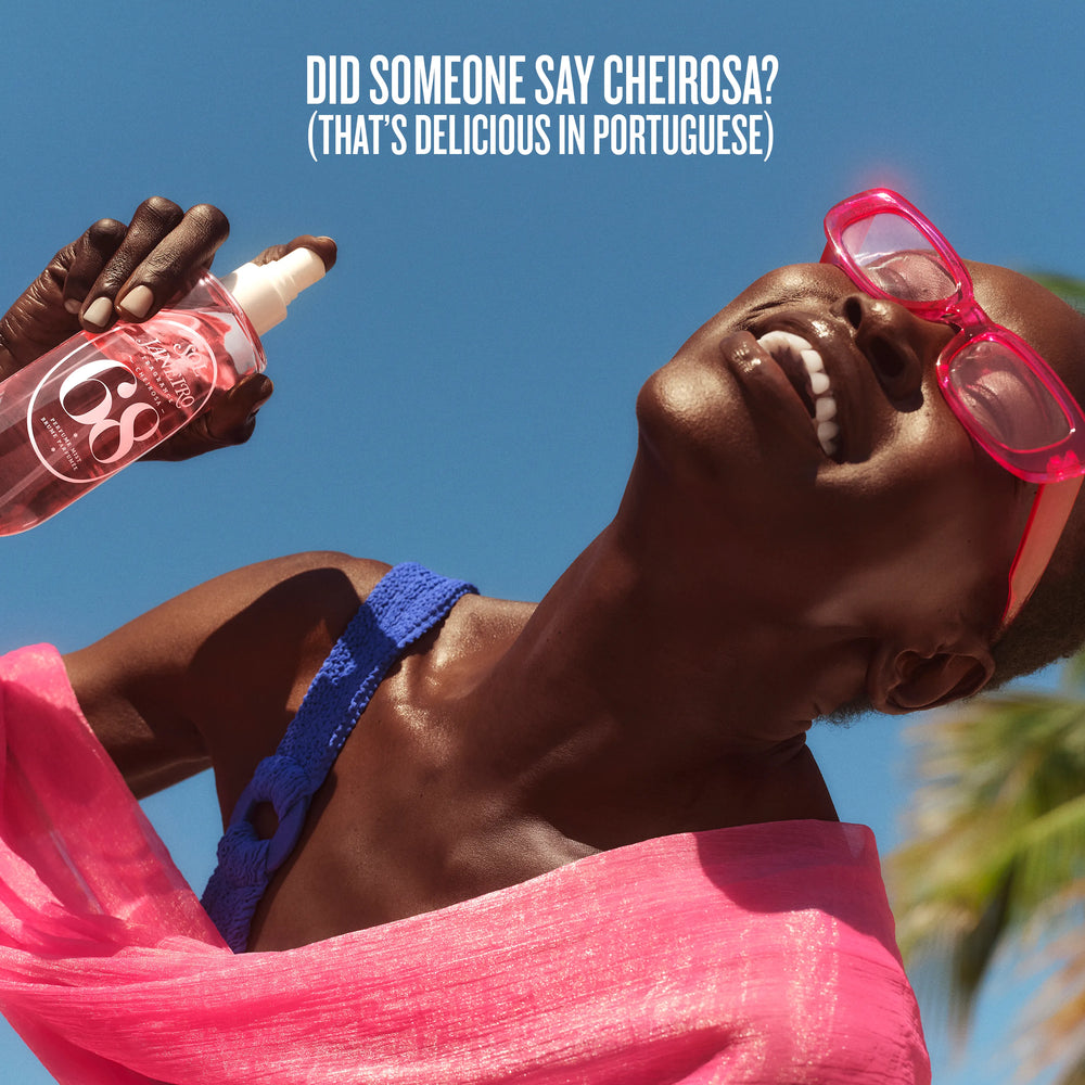 Person wearing pink sunglasses and blue bikini top, with a bottle labeled 'C6' against a clear blue sky.