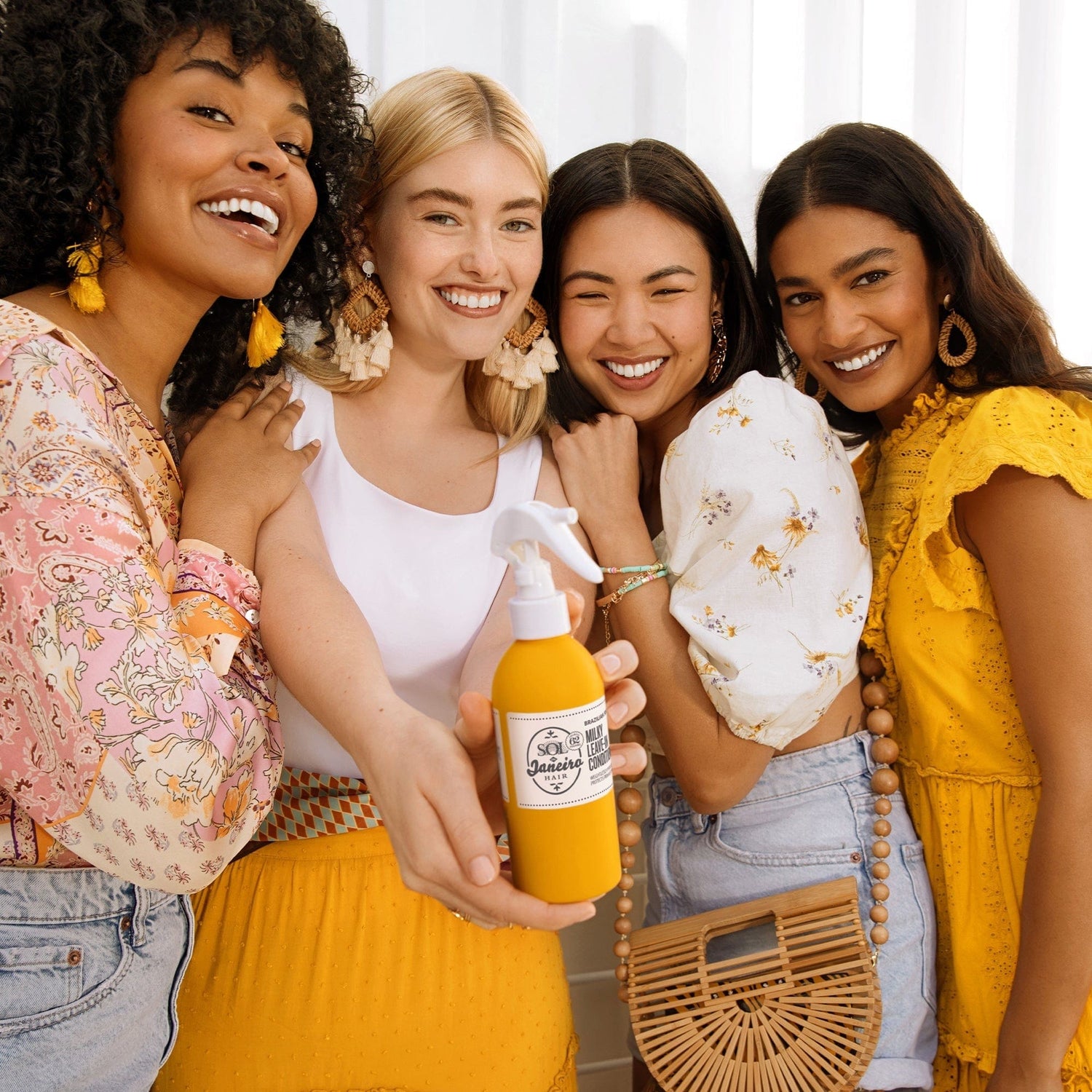 Models smiling with the Brazilian Joia Milky leave-in conditioner