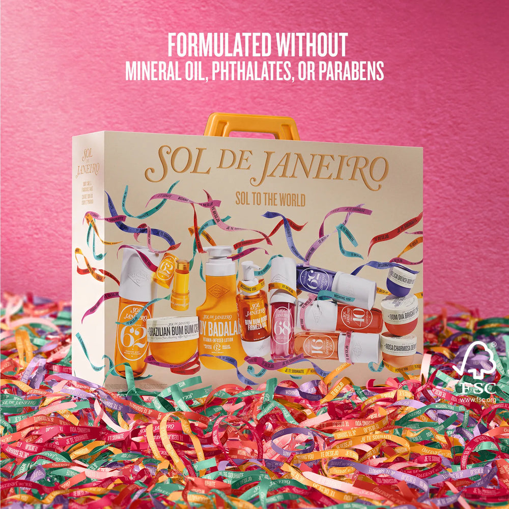A gift set box labeled 'SOL DE JANEIRO' sits on colorful shredded paper against a pink background, with marketing text at the top stating it is formulated without mineral oil, phthalates, or parabens.