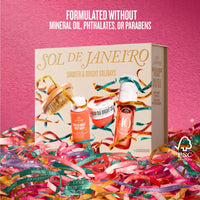 Sol de Janeiro Smooth & Bright Soldays gift set box displayed on a pink background with colorful ribbons around the base. The box features illustrations of skincare products and the brand name 'Sol de Janeiro' in gold lettering.