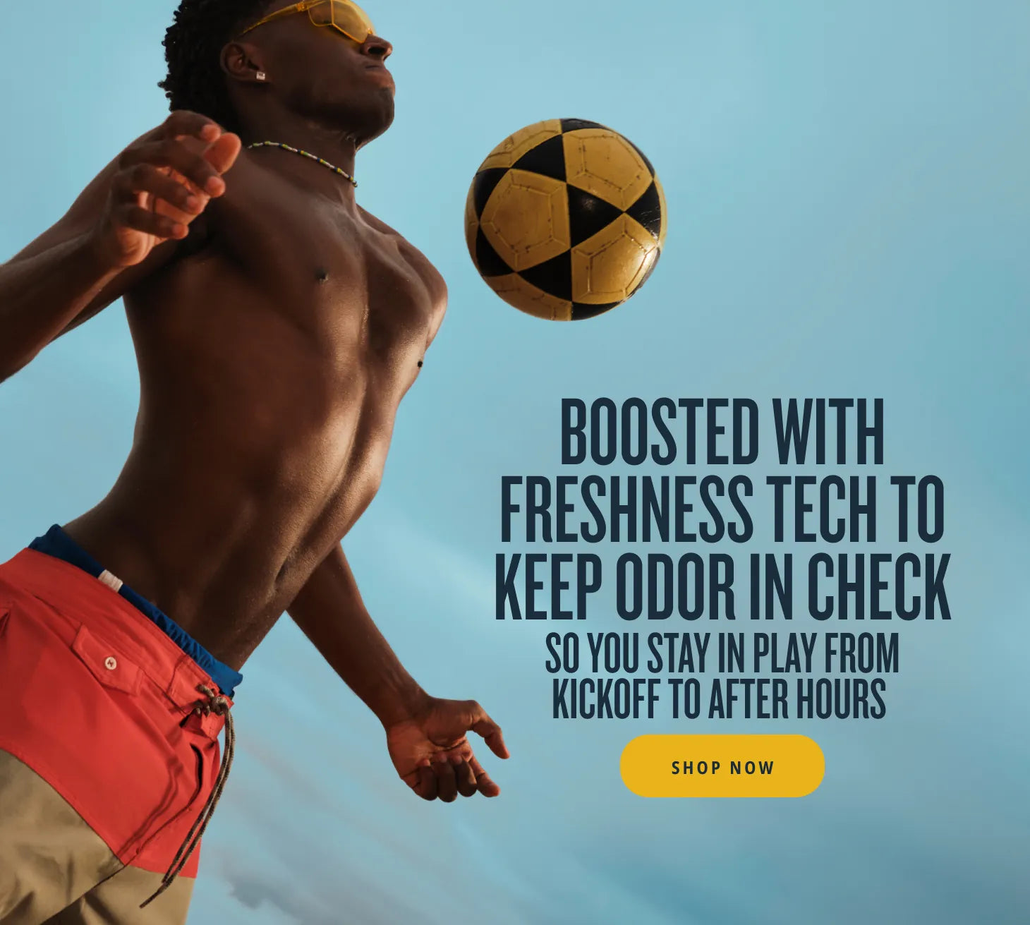A shirtless man in swim trunks and yellow sunglasses looks up at a yellow and black soccer ball mid-air against a blue sky. Text reads: 'BOOSTED WITH FRESHNESS TECH TO KEEP ODOR IN CHECK SO YOU STAY IN PLAY FROM KICKOFF TO AFTER HOURS' with a yellow Shop Now button. A shirtless man in swim trunks and yellow sunglasses looks up at a yellow and black soccer ball mid-air against a blue sky. Text reads: 'BOOSTED WITH FRESHNESS TECH TO KEEP ODOR IN CHECK SO YOU STAY IN PLAY FROM KICKOFF TO AFTER HOURS' with a yellow Shop Now button.
