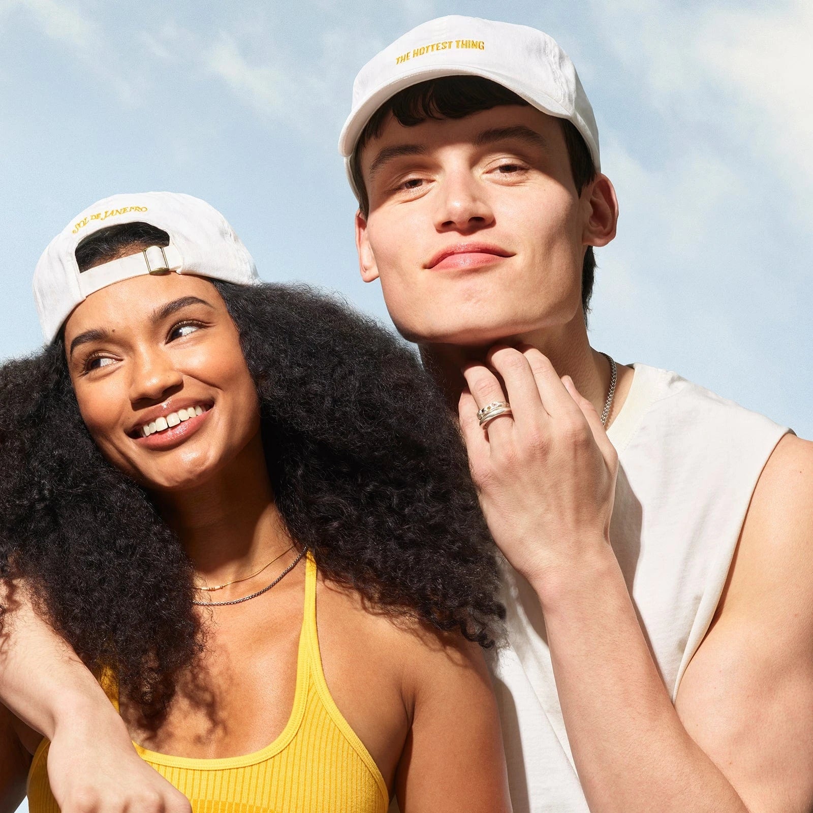 Models smiling wearing the Sol de Janeiro Badalada baseball hat