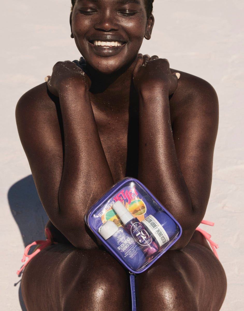 Person holding a compact mirror with a visible brand logo on a plain background