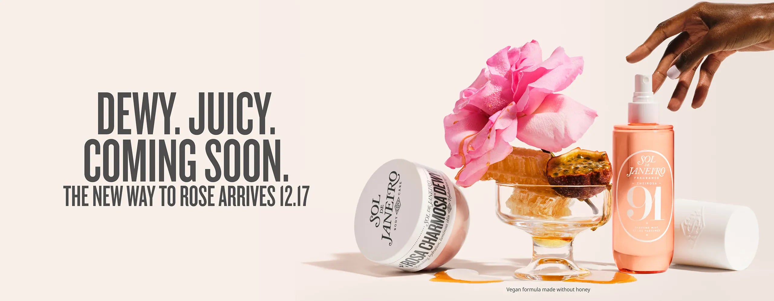 Cosmetic products with a pink flower and text about a new product release. Text on image reads dewy. juicy. coming soon. the new way to rose arrives 12.17