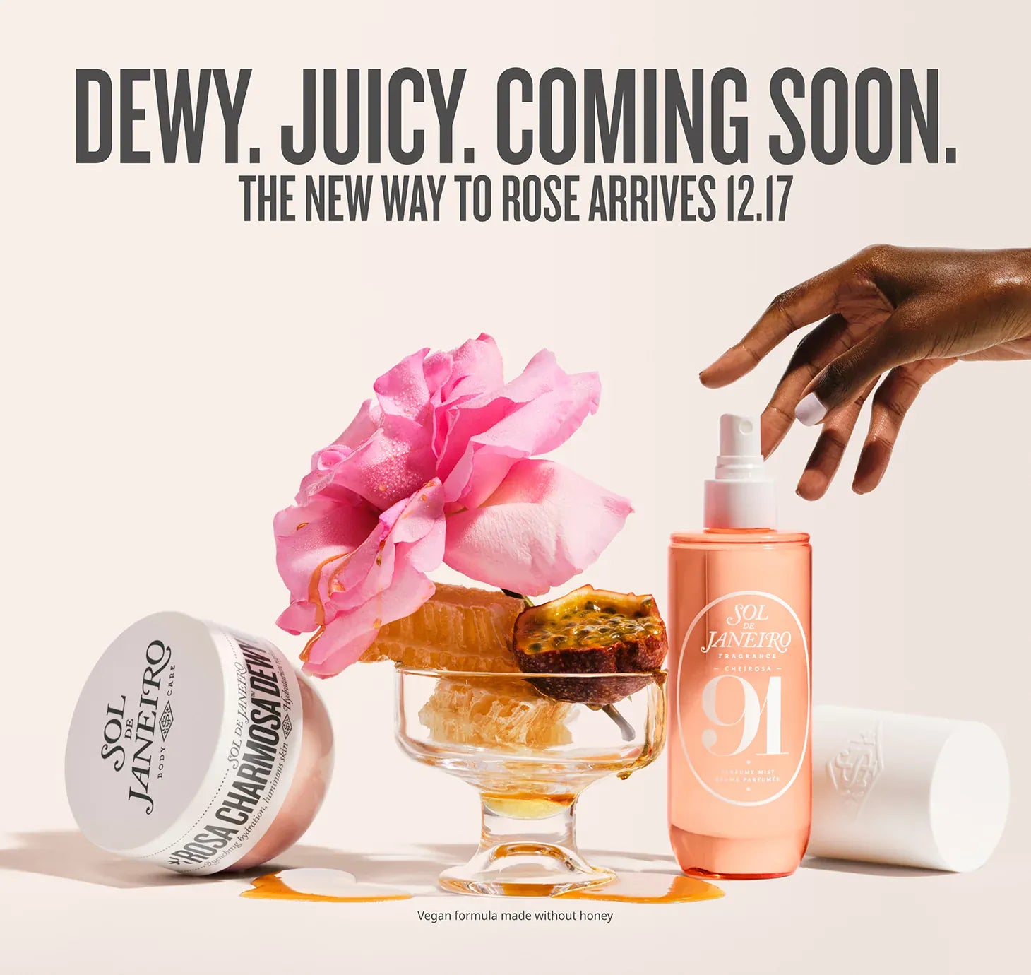 Cosmetic products with a pink flower and text about a new product release. Text on image reads dewy. juicy. coming soon. the new way to rose arrives 12.17