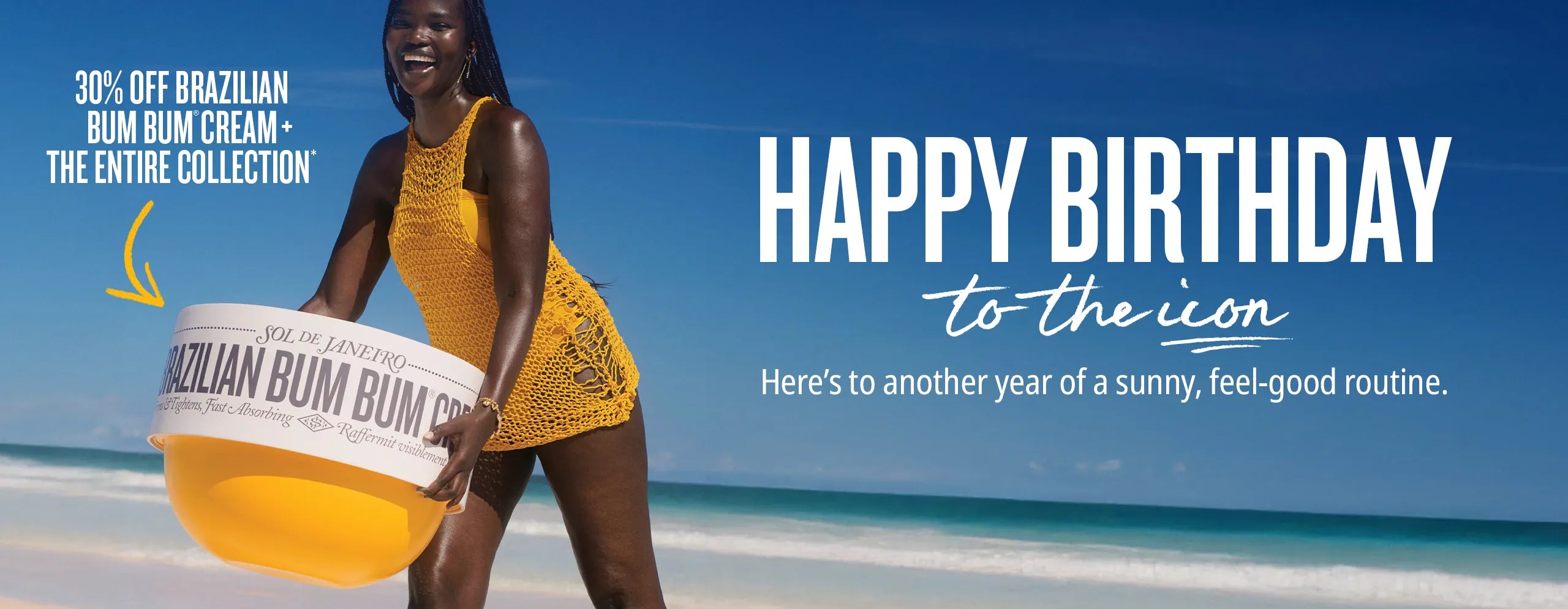 Woman holding a Brazilian Bum Bum Cream container on a beach with a blue sky.