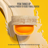 A jar of Sol de Janeiro Brazilian Bum Bum Cream is shown against a bright yellow background with a cream-colored splash. The jar has a light wood-grain label with the brand name and product name printed on it.