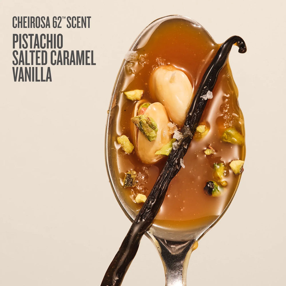 A spoonful of Pistachio Salted Caramel Vanilla scent from Cheirosa 62° Scent, featuring a glossy amber-brown syrup with pistachio pieces, a vanilla bean, and coarse salt, set against a light beige background with dark gray text.