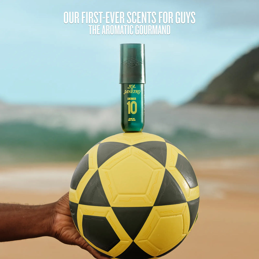 Scent bottle on a soccer ball held by a hand with beach background