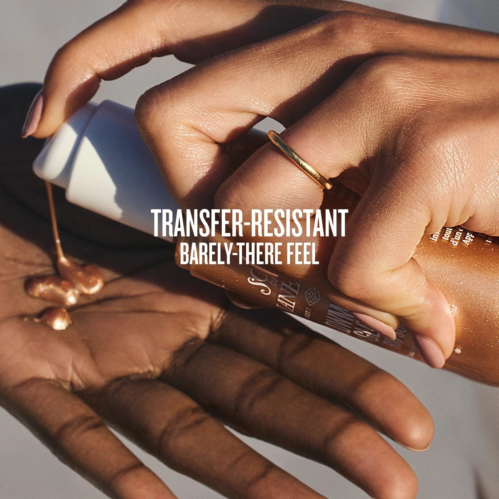 Text on image reads transfer-resistant barely-there feel. This is an image of a close up of two hands putting on the sol de janeiro glowmotions glow body oil using the rio sunset shade