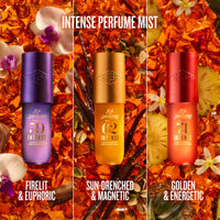 Three cylindrical perfume mist bottles from Sol Janiero are shown side by side against a rich background of orange flower petals, vanilla beans, and white orchids. The bottles are labeled 'INTENSE PERFUME MIST' and feature three different metallic colors: purple, gold, and red.