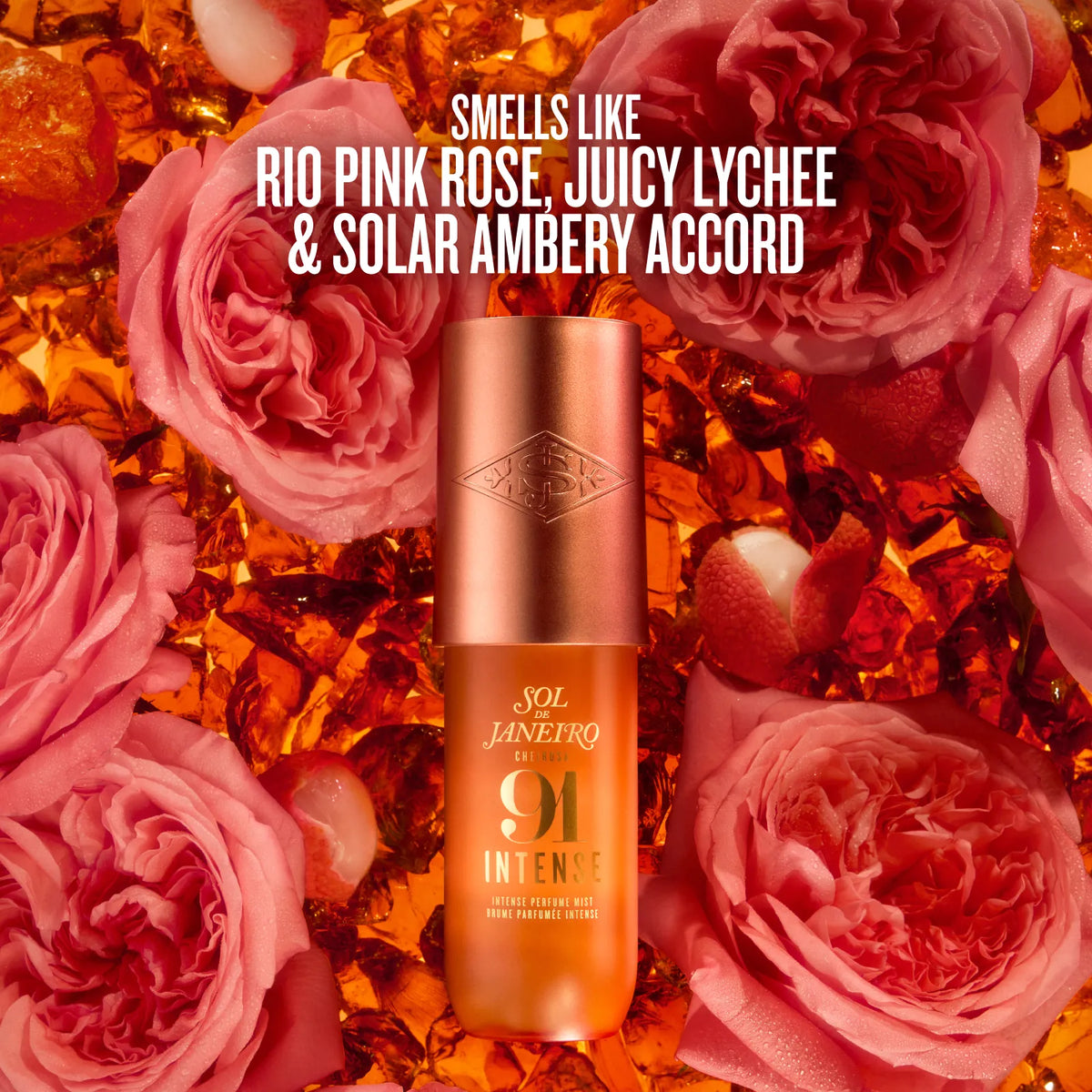 A bottle of Sol Janeiro 91 Intense perfume mist is centered against a background of pink roses and amber, with white text reading 'SMELLS LIKE RIO PINK ROSE, JUICY LYCHEE & SOLAR AMBERY ACCORD'.