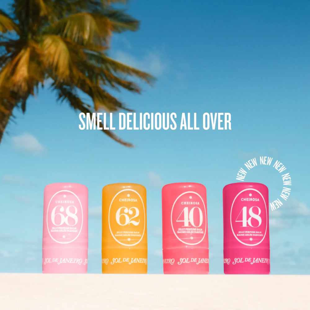 Four colorful sunscreen stick tubes labeled CHERRISA 68, 62, 40, and 48 are lined up on a white surface against a tropical beach background with a blue sky and palm tree. White text above reads 'SMELL DELICIOUS ALL OVER' and a circular badge says 'NEW NEW NEW NEW'.