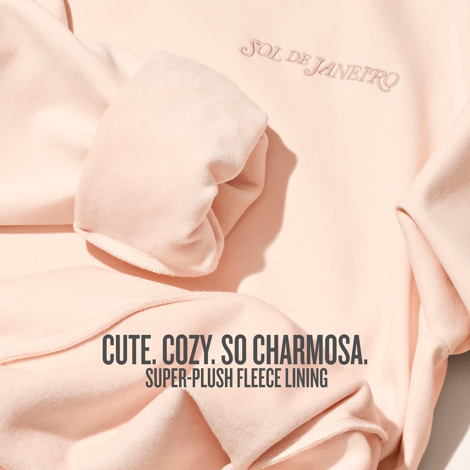 Pink fleece garment with text about plush lining and brand name.